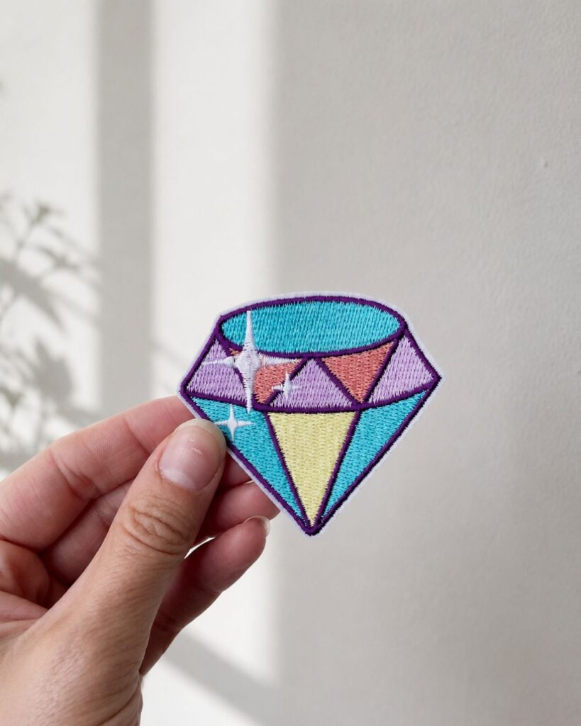 Diamant strygemærke i pastelfarver. Broderet mærke til tøj og tasker i lilla, turkis, rosa og gul.