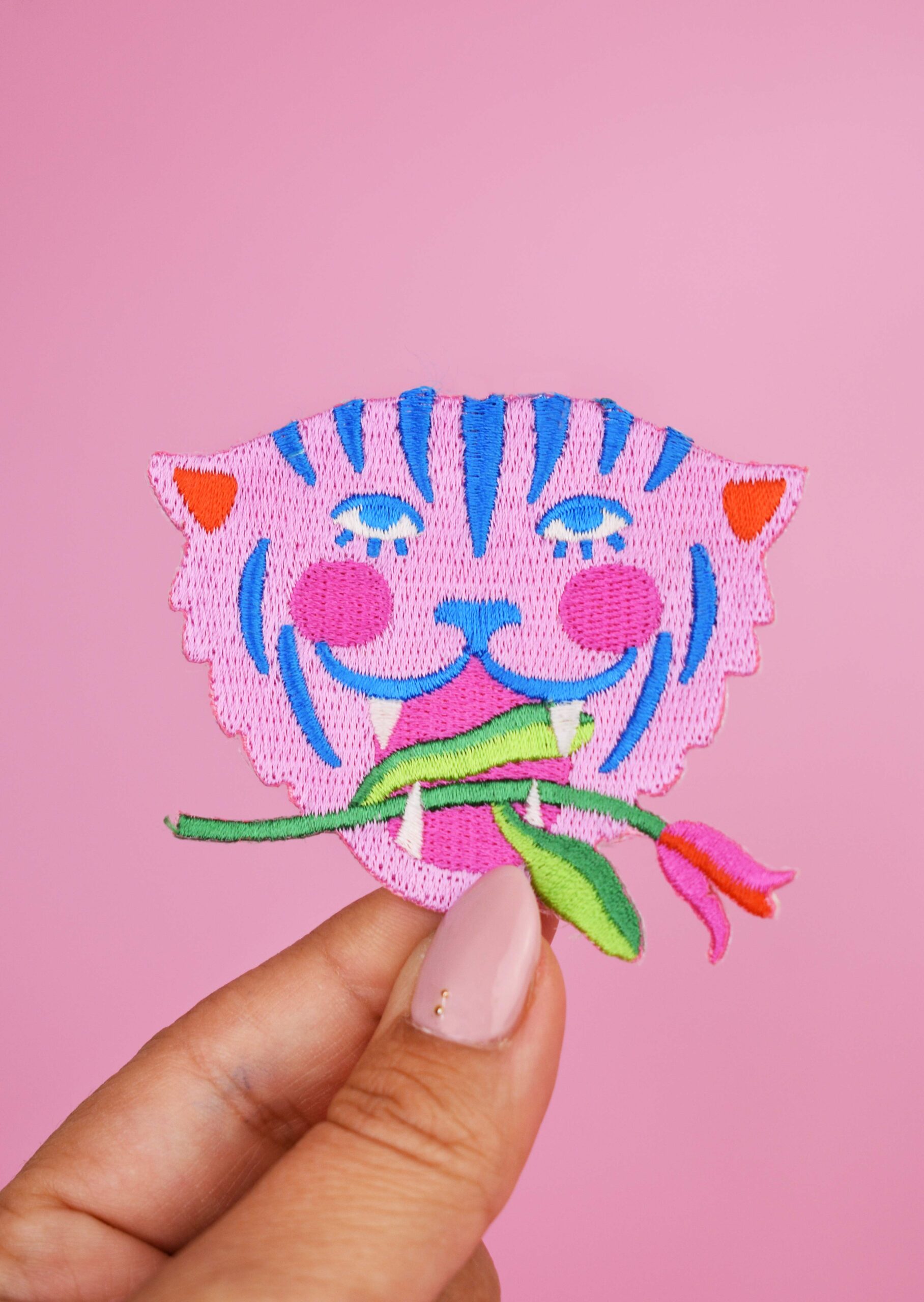 Broderet strygemærke med tiger og blomst i blå og rosa farver til reparation og dekoration af tøj og tasker.
